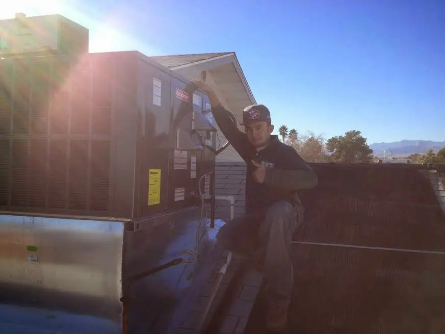 HVAC technician performing Air Duct Cleaning on a rooftop unit in Chamblee